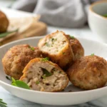 Boulettes de porc haché maison dorées et croustillantes sur une assiette blanche