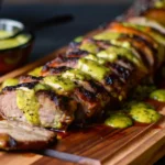 Filet de porc mariné grillé servi avec légumes colorés, parfait pour une cuisson au four ou au barbecue.